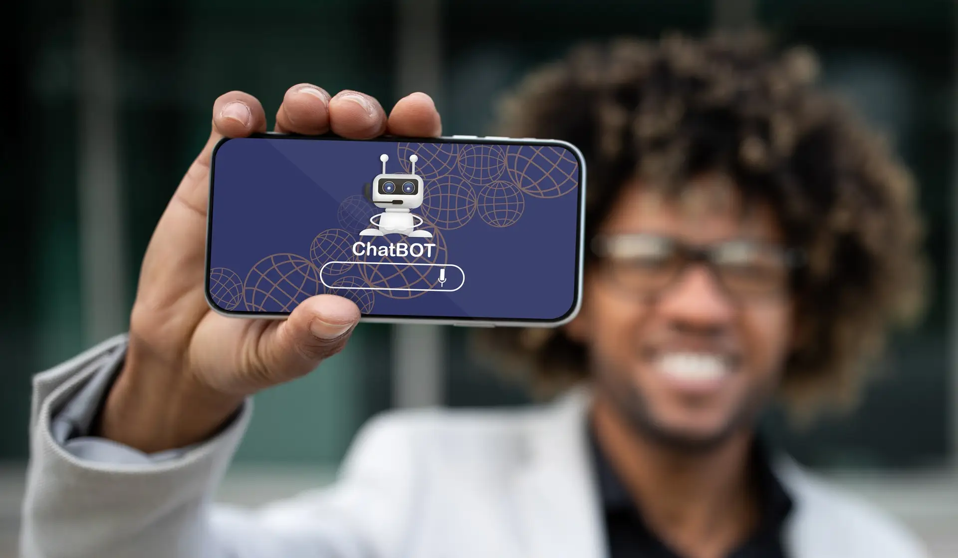 Digital Intelligence & Marketing.Positive african american entrepreneur showing phone with chatbot